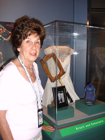 Maria Esther Bueno ao lado da raquete, roupa e tênis usados numa partida entre Brasil e Venezuela. Foto: Site Oficial