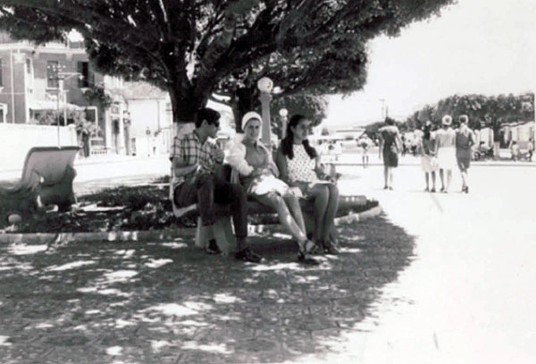 Pessoas conversam no banco da praça enquanto as moças, ao fundo, passeiam em uma tarde ensolarada de Muzambinho. Foto enviadas por Antonio Carlos Pestili Fonseca, enviada por sua prima Yara