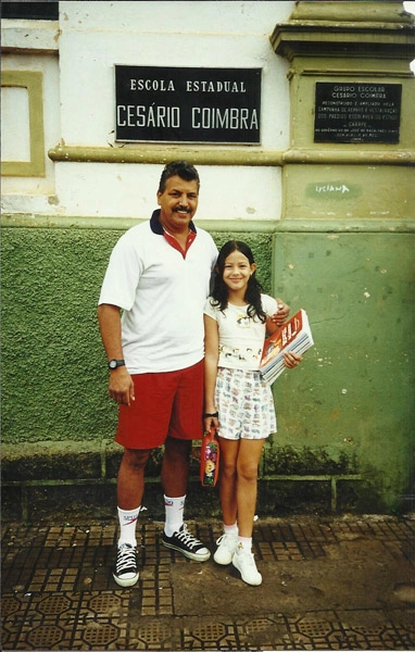 Guilherme Vicente de Souza em frente à Escola Estadual Cesário Coimbra, na Praça dos Andradas, Muzambinho-MG, com sua sobrinha Naiana, em 2000. Foto: arquivo pessoal de Gulherme