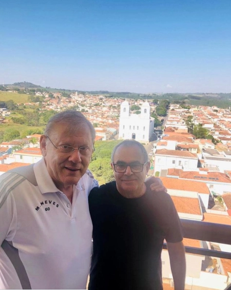 Em 8 de maio de 2021, Milton Neves ao lado do amigo Paulinho Chumbinho, em Muzambinho. Atrás, a Paróquia São José