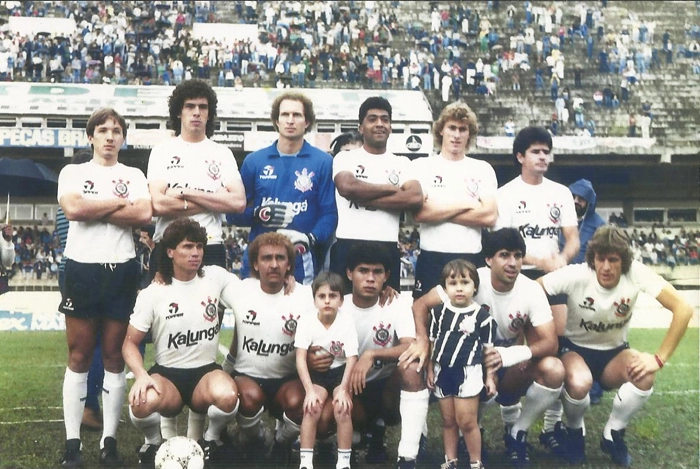 Jogadores do Corinthians posam para foto no Estádio Brinco de Ouro, em Campinas, antes de enfrentar o Guarani no dia 17 de agosto de 1986 pelo Campeonato Paulista. Vitória corintiana por 3 a 1 (gols de Cacau, Biro-Biro e Lima para o Alvinegro). No final, Evair marcou o gol de honra bugrino. Na ocasião, Rubens Minelli era o técnico do Corinthians, que promoveu duas alterações ao longo do jogo: Cristóvão no lugar de Casagrande e Dicão no lugar de João Paulo. Da esquerda para a direita: Cacau (ex-Goiás e Flu), Casagrande, Carlos, Lima, Wilson Mano e João Paulo. Agachados: Édson Boaro, Biro-Biro, Aílton, Paulo e Edivaldo. Foto enviada por Emílio A. Duva. Informações sobre os detalhes do jogo: Almanaque do Timão, de Celso Unzelte