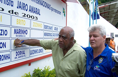 Mengálvio, em dezembro de 2007, assinando o Muro da Fama do Cordeiro FC, da cidade de Cordeiro (RJ). Jairo Amaral, presidente do clube, está ao lado.