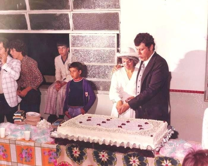 Casamento de Milton Neves e Lenice em 07 de janeiro de 1978, em Muzambinho-MG. Eles partem o bolo para os convidados, entre eles. à esquerda, Ivan Surdão, de terno xadrez, cortado na imagem